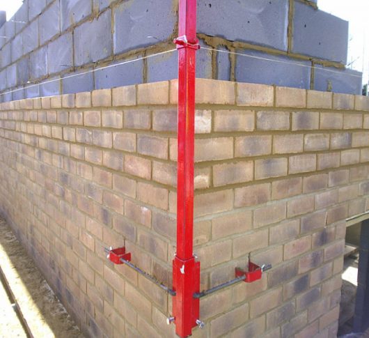 Red steel Mustang 6' External Profile fixed onto the outside corner of a wall in the process of being built