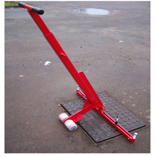 Red steel Mustang pivot lift manhole cover lifter with white wheels lifting a rectangular manhole cover