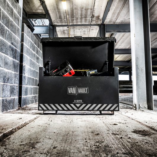 Black sheet steel Van Vault 4-site with lid open and work equipment in, in a building site