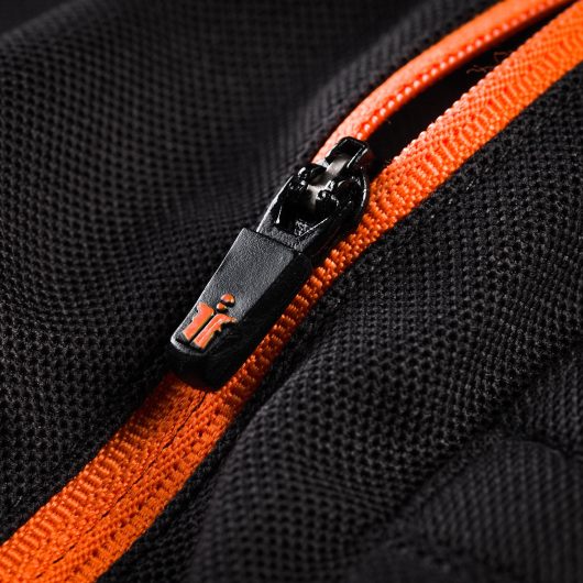Close up of the black and orange zip on the chest of the Scruffs trade active polo with orange Scruffs logo at bottom of zip